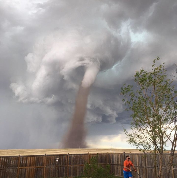 мужчина косил газон перед торнадо