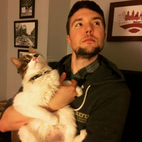 мужчина обнимается с кошками
