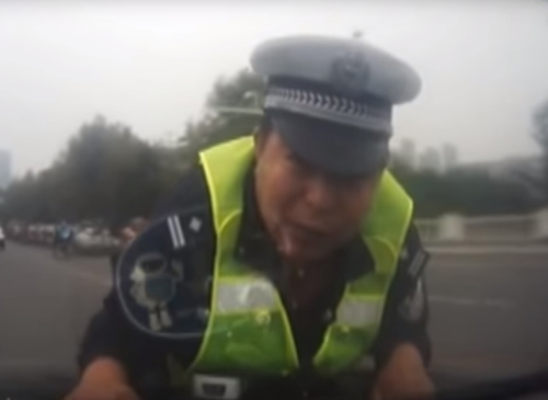 полицейский на капоте машины