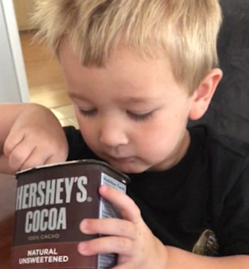 мальчик пробует какао-порошок