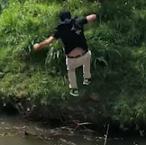 гольфист прыгнул через ручей