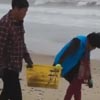 супруги чистят пляж от мусора