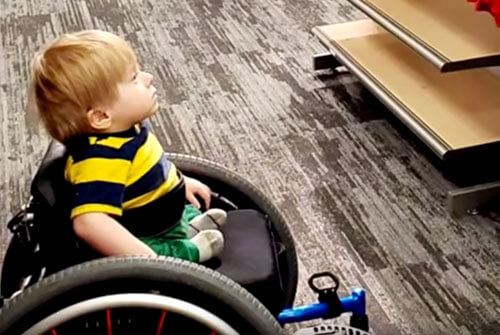малыш в инвалидной коляске