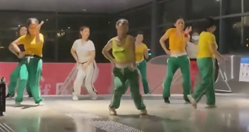 женщины танцуют возле метро