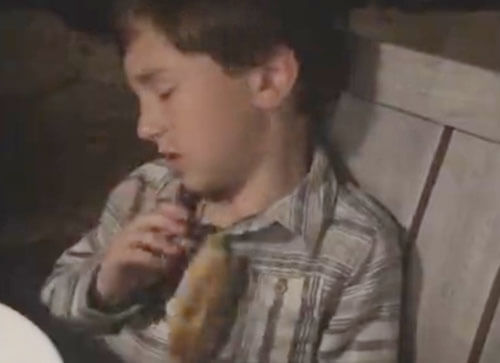 сонный мальчик ест пиццу