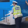 полицейский толкает автобус