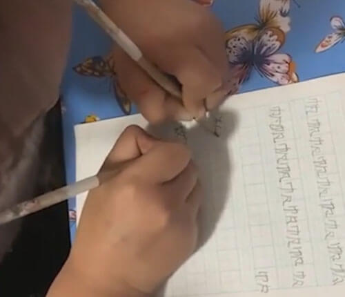 школьница пишет двумя руками