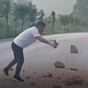 водитель убирает камни с дороги
