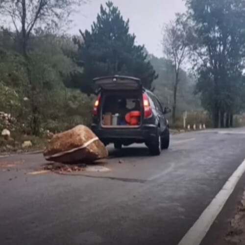 водитель убирает камни с дороги