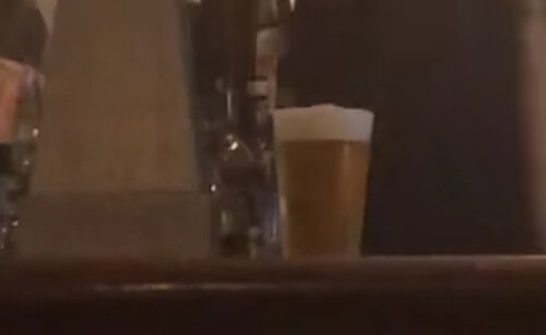 бармен наливает пиво в стакан