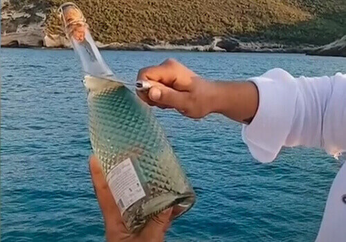 мужчина утопил бутылку в море